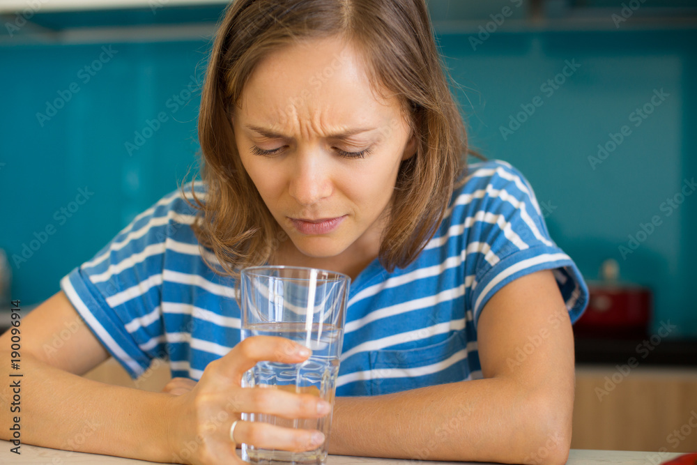 Photo of Girl Looking Into an Unappealing Glass of Water